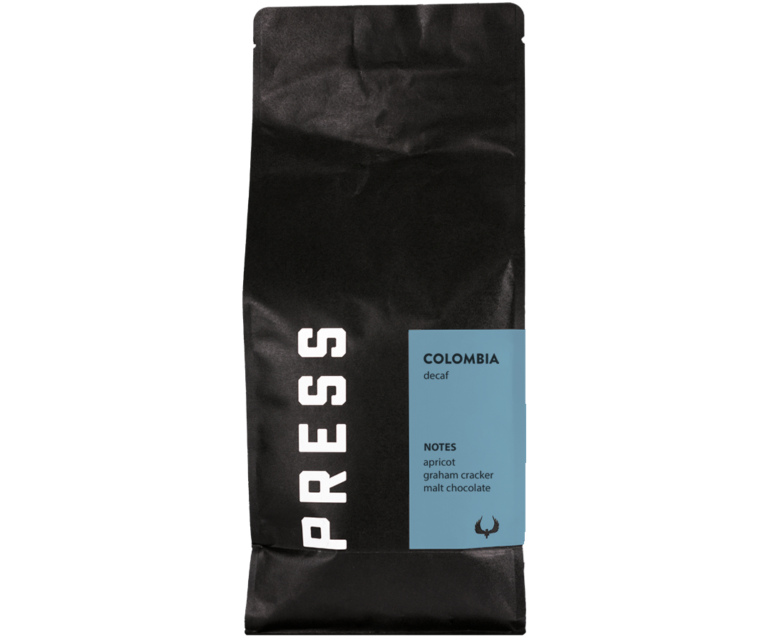 Black coffee bag with 'PRESS' branding and Colombia decaf information on a white background